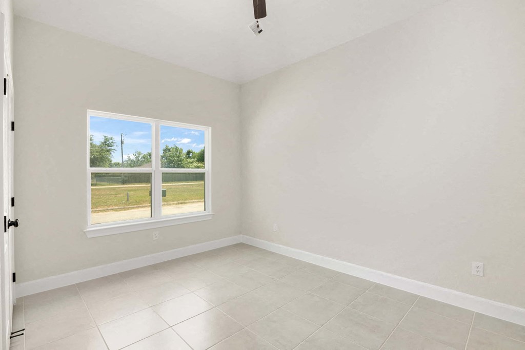an empty room with a window and a tiled floor