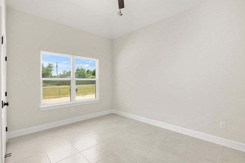 an empty room with a window and a tiled floor