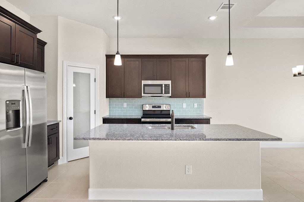 a kitchen with a counter top and a stainless steel refrigerator