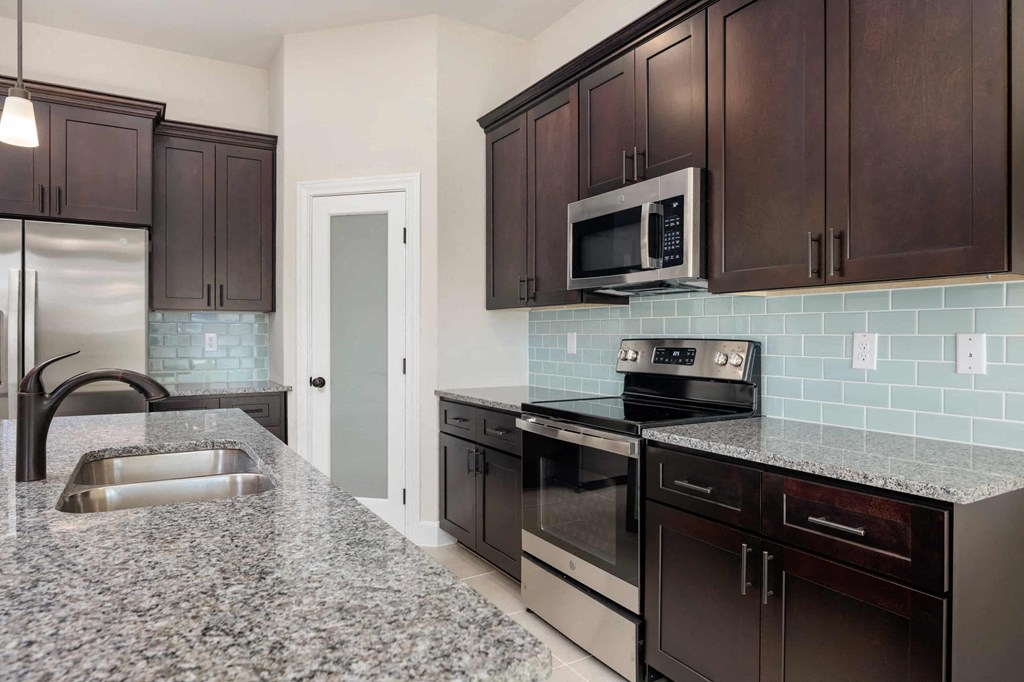 a kitchen with granite counter tops and stainless steel appliances