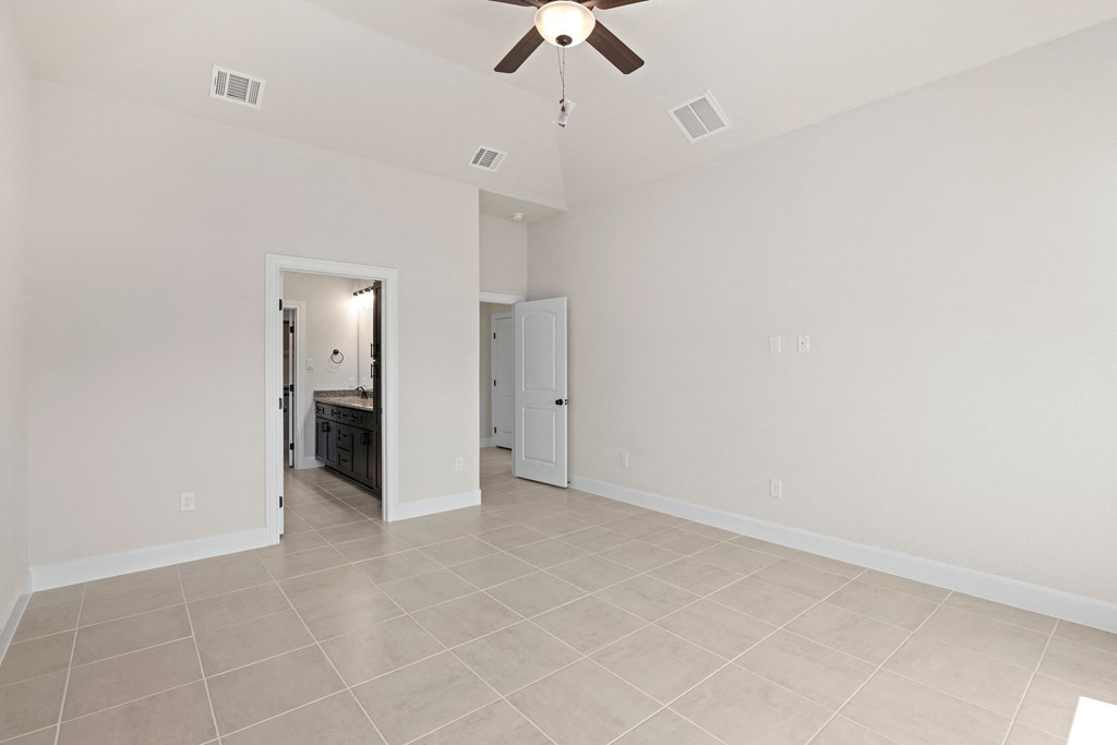 the living room and dining room of an empty house with a ceiling fan