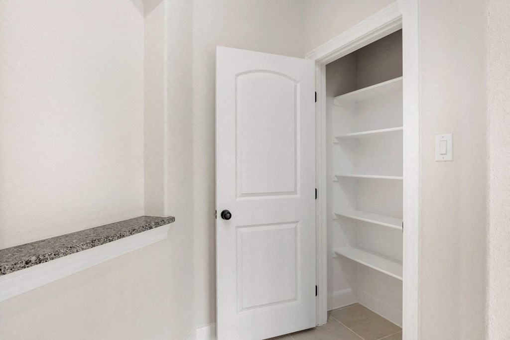 a white closet with shelves and a white door