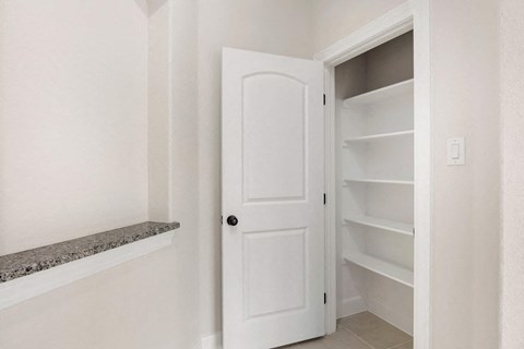 a white closet with shelves and a white door