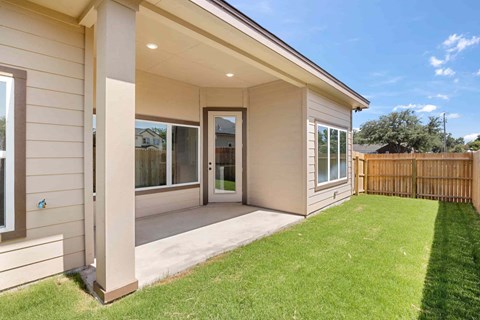 the front porch of a house with a lawn and a backdoor