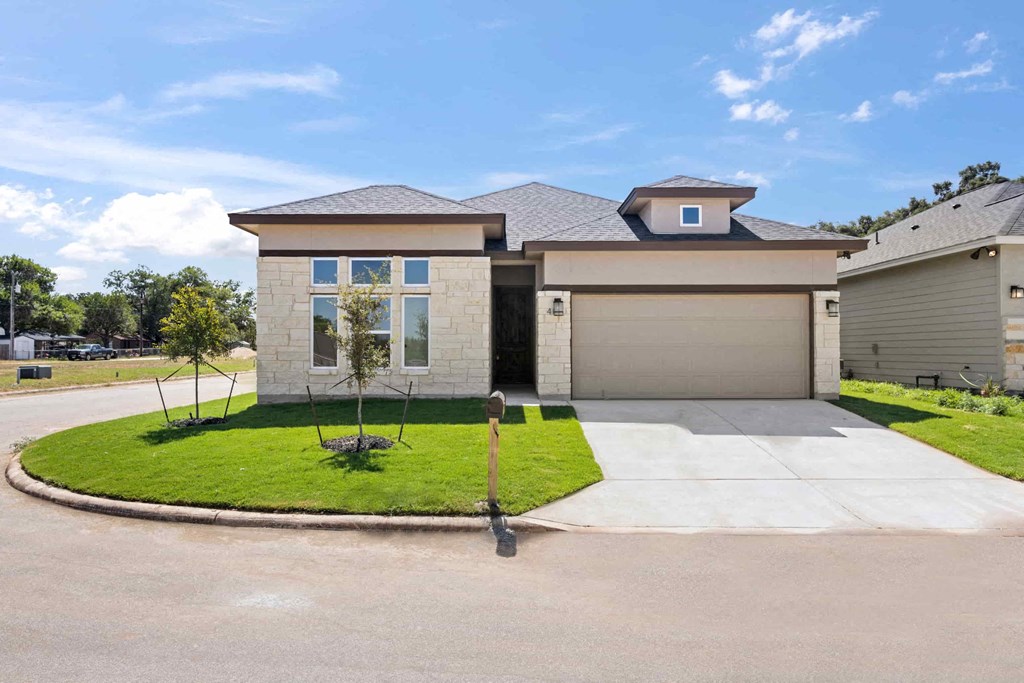 a house with a driveway and a lawn in front of it
