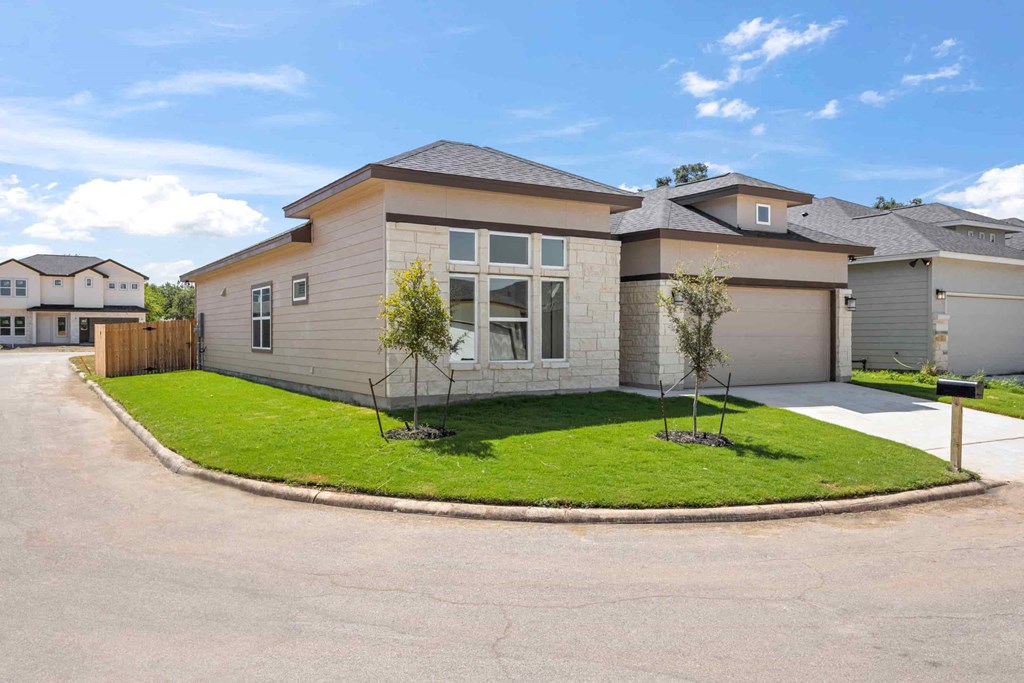 a house with a driveway and lawn in front of it