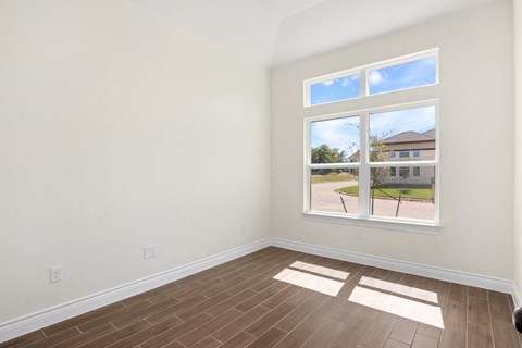 a living room with a window and wooden floors