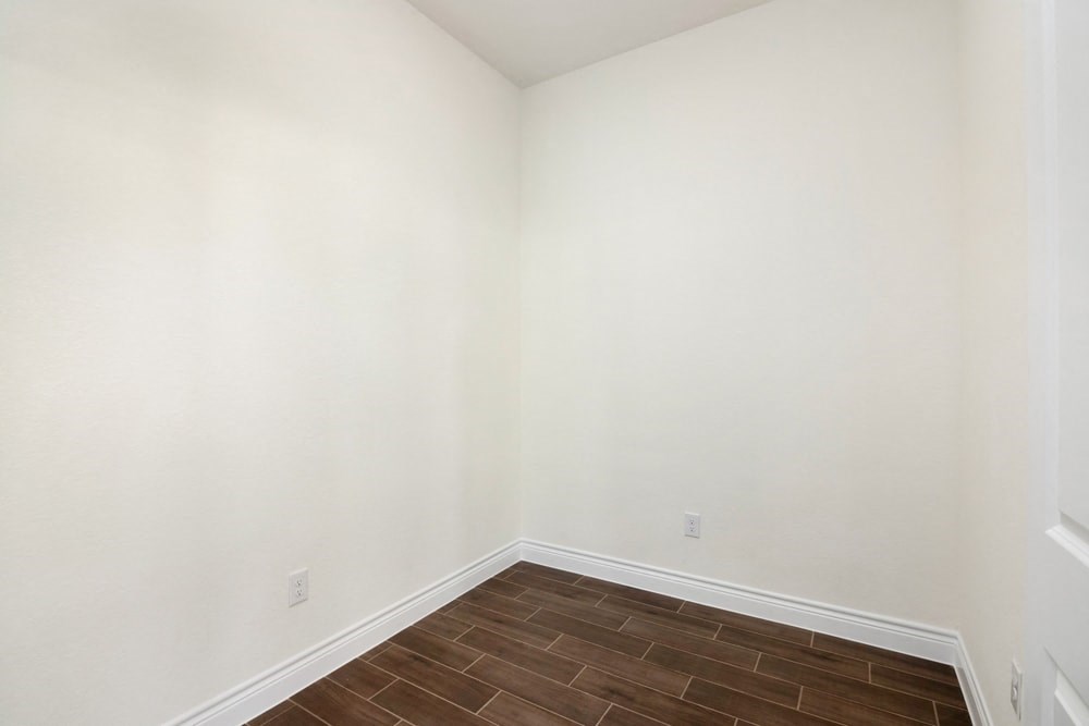 a empty room with a wooden floor and white walls