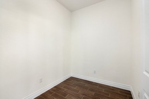 a empty room with a wooden floor and white walls