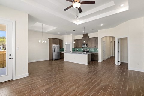an open kitchen and living room with a ceiling fan