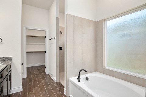 a bathroom with a tub and a large window