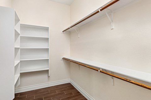 a walk in closet with shelves and a bench