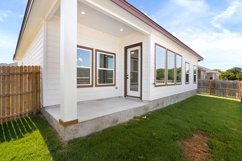 the front of a white house with windows and a lawn