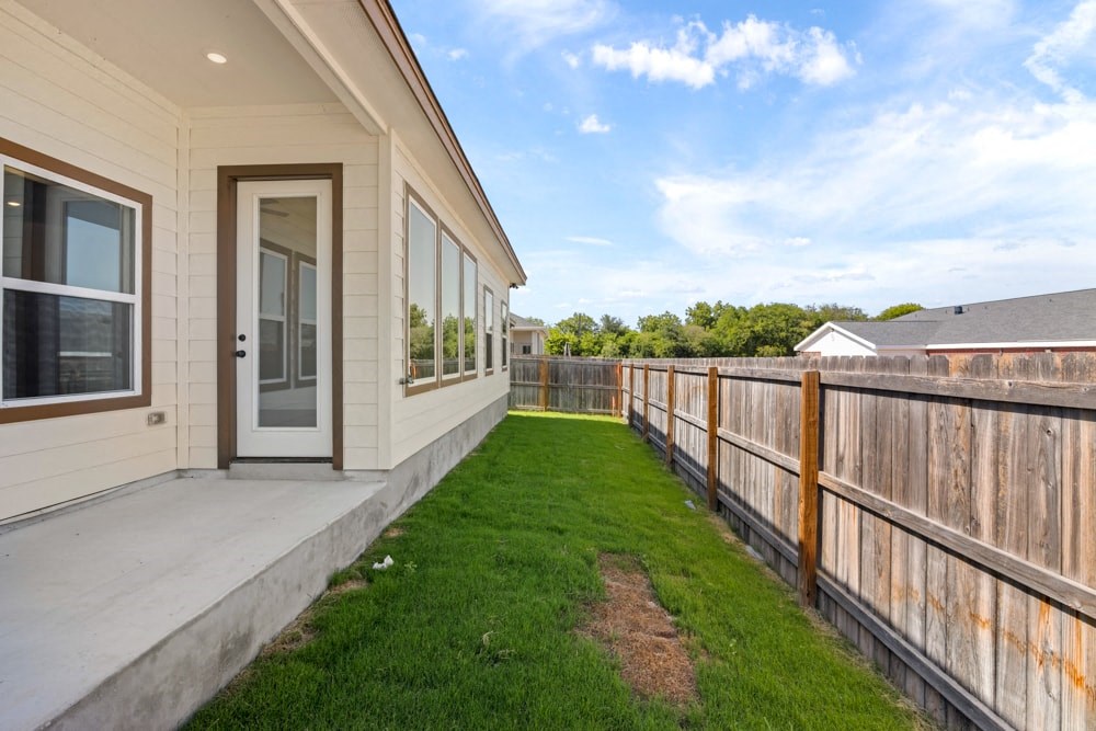 the back deck of a house with a yard and a door