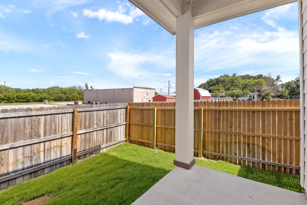 the backyard of a house with a wooden fence and grass