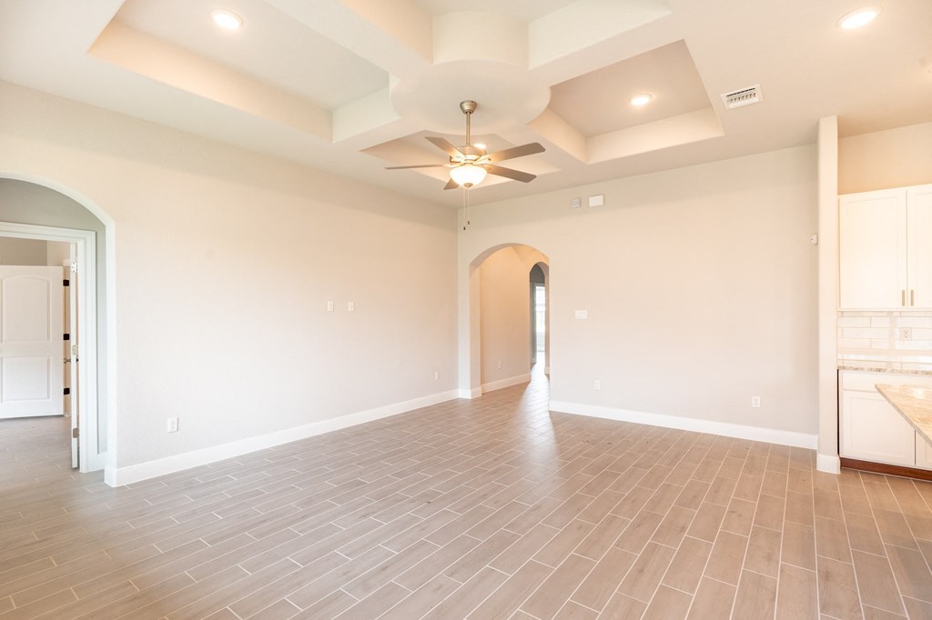 the spacious living room with a ceiling fan and tile flooring
