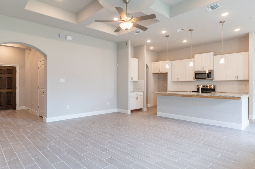 an open kitchen and living room with a ceiling fan