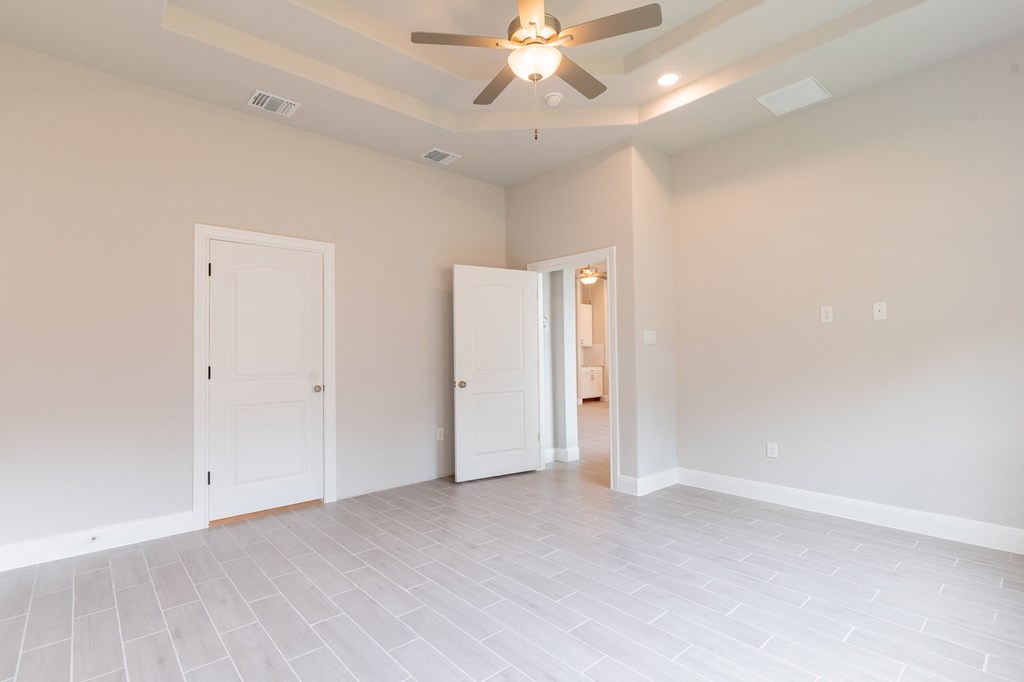 the living room of an empty house with a ceiling fan