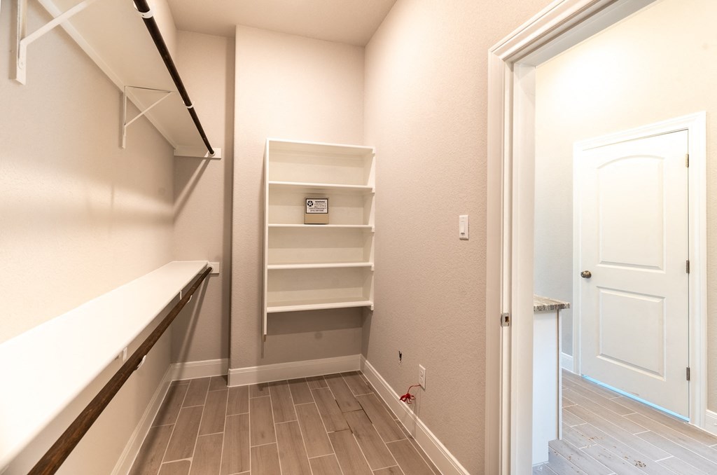 a walk in closet with shelves and a white door
