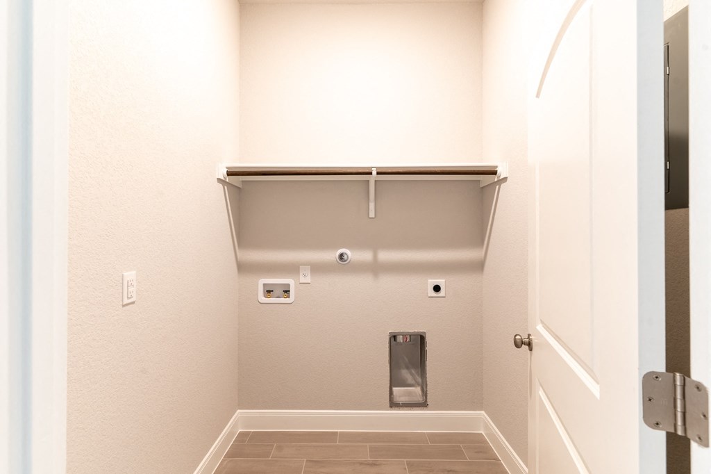 an empty hallway with a white door and a urinal on the wall