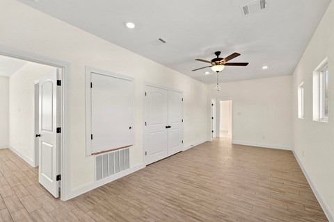 a living room with white walls and a ceiling fan