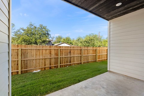 a backyard with a wooden fence and a yard with grass