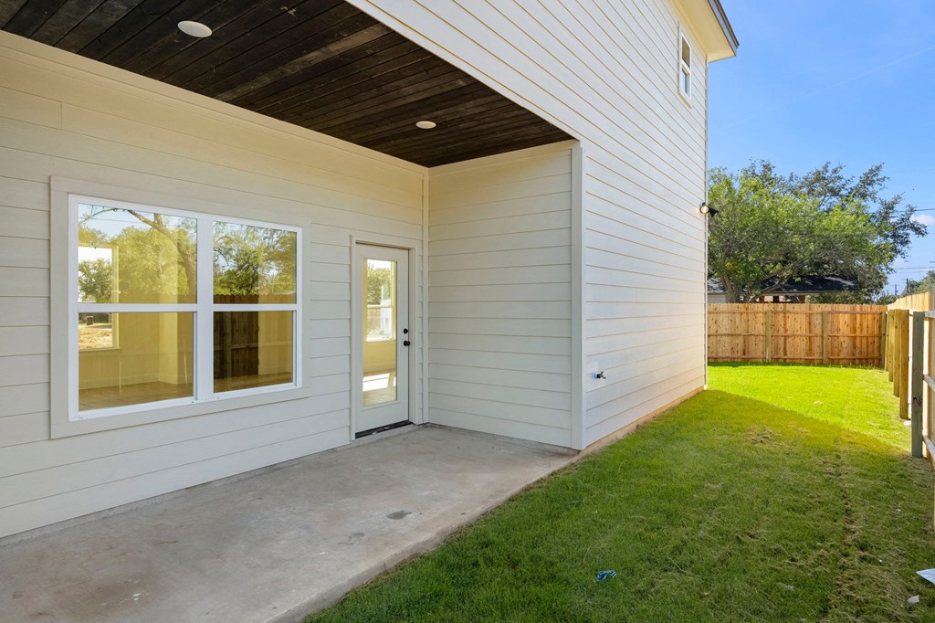 the entrance to a home with a patio and grass
