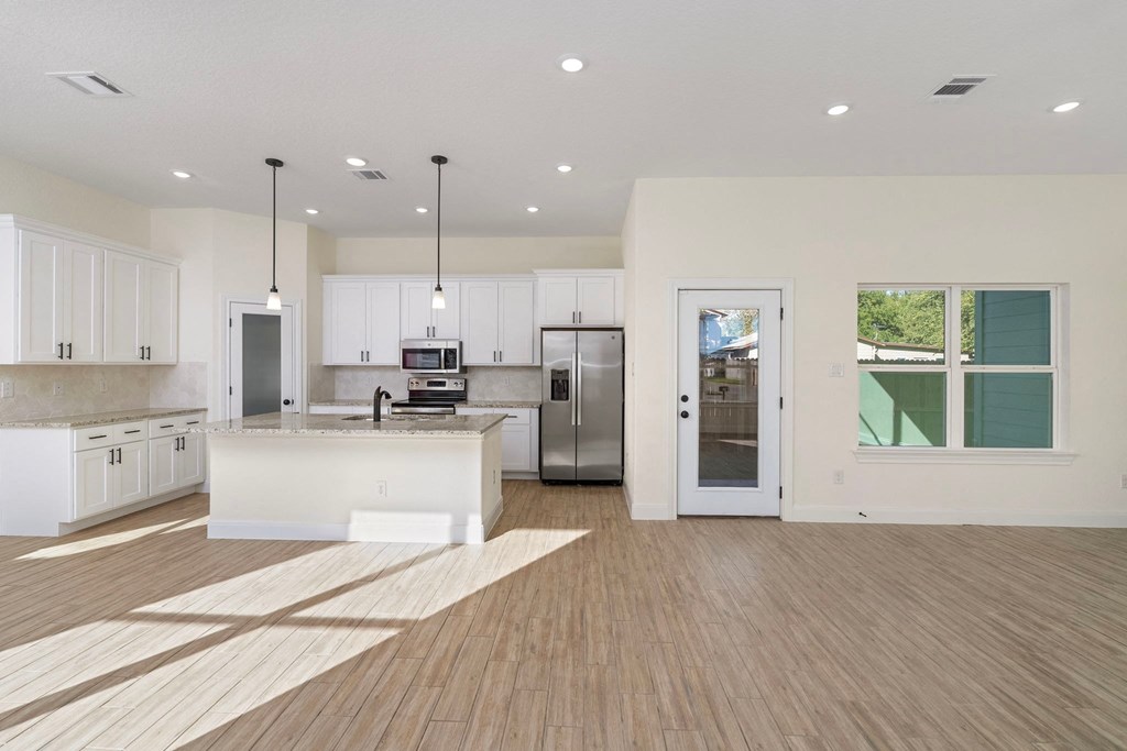 a large kitchen with white cabinets and stainless steel appliances