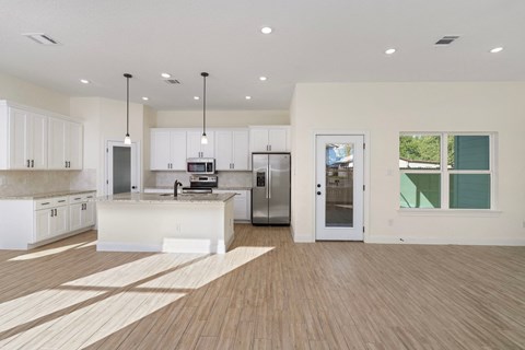 a large kitchen with white cabinets and stainless steel appliances
