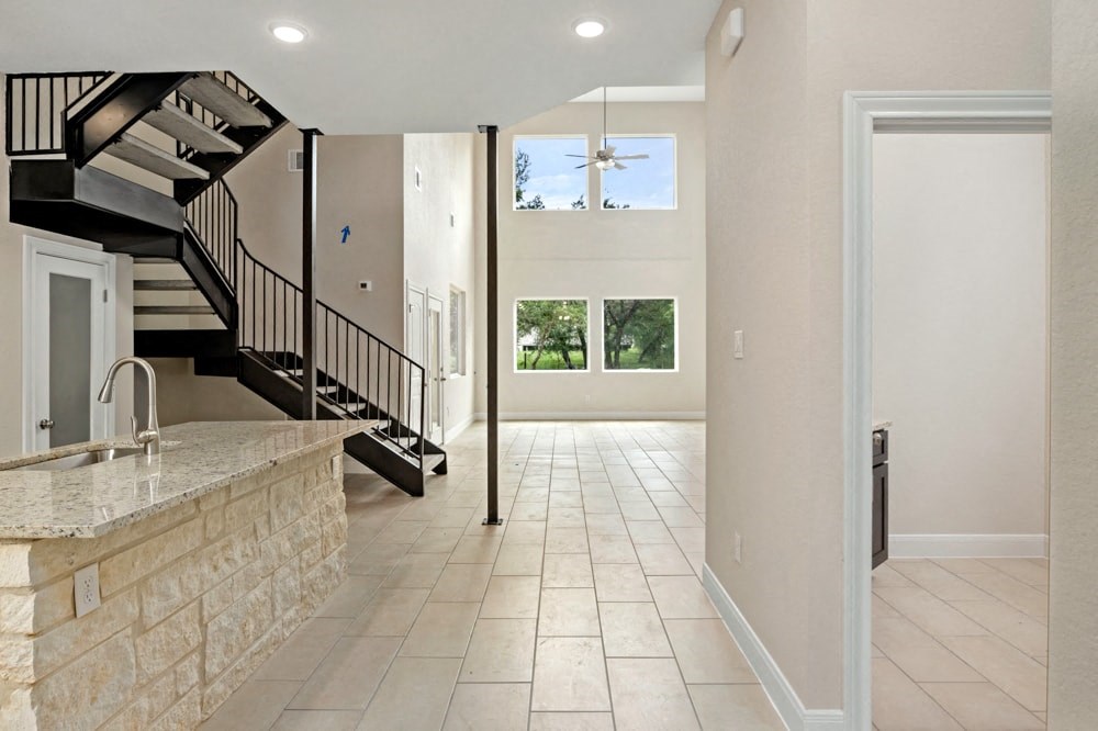 the kitchen is open to the living room and the staircase to the second floor