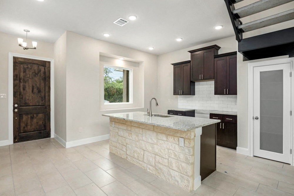 a large kitchen with a marble counter top