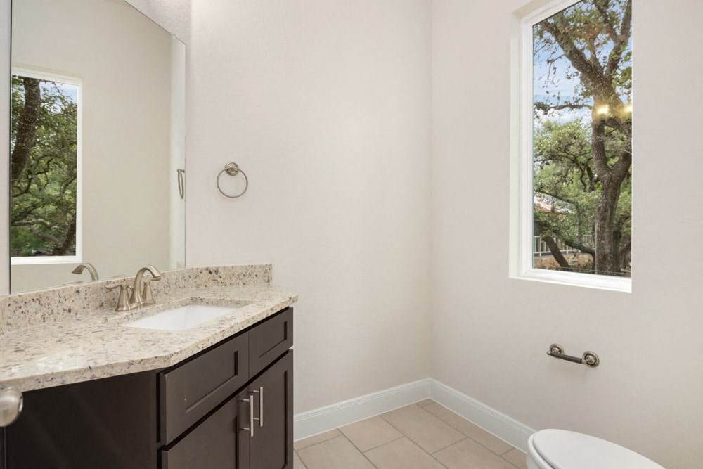 a bathroom with a sink and a toilet and a window