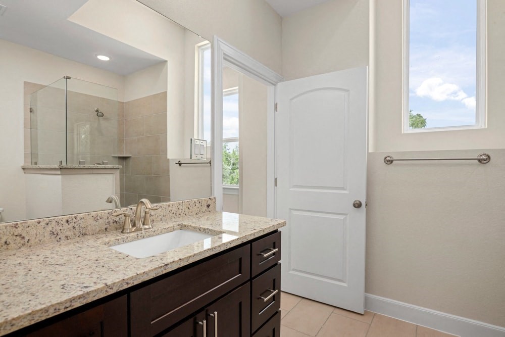 a bathroom with a sink and a mirror and a shower