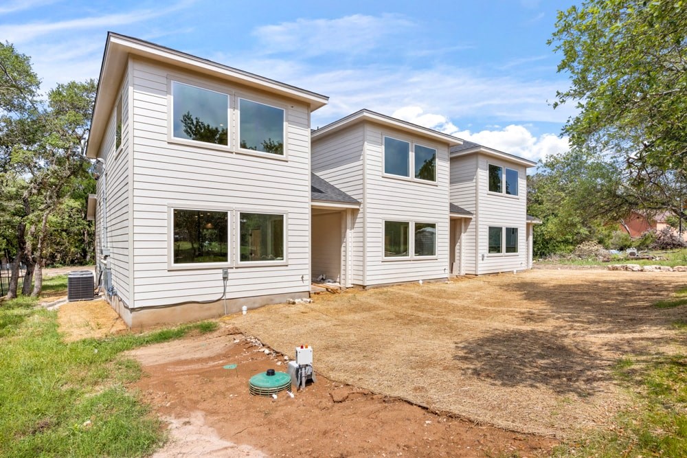 a white house with a dirt yard in front of it