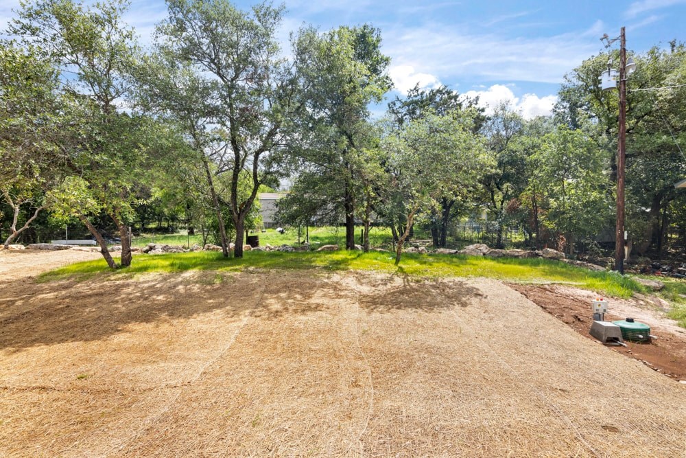 a dirt field with trees and a truck in the middle of it