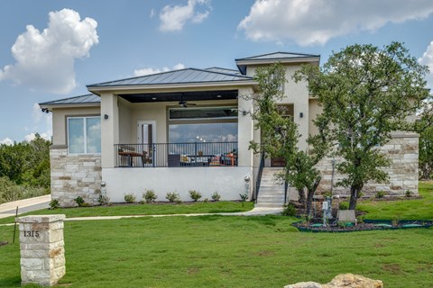a house with a lawn and trees in front of it