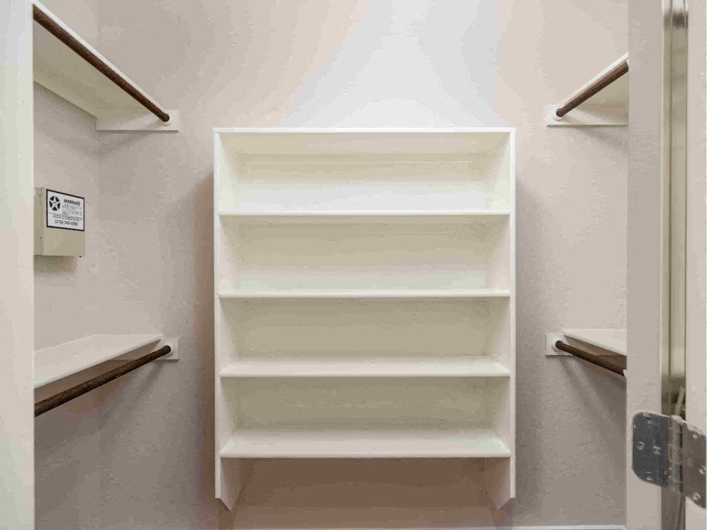 a closet with white shelves and a white closet door