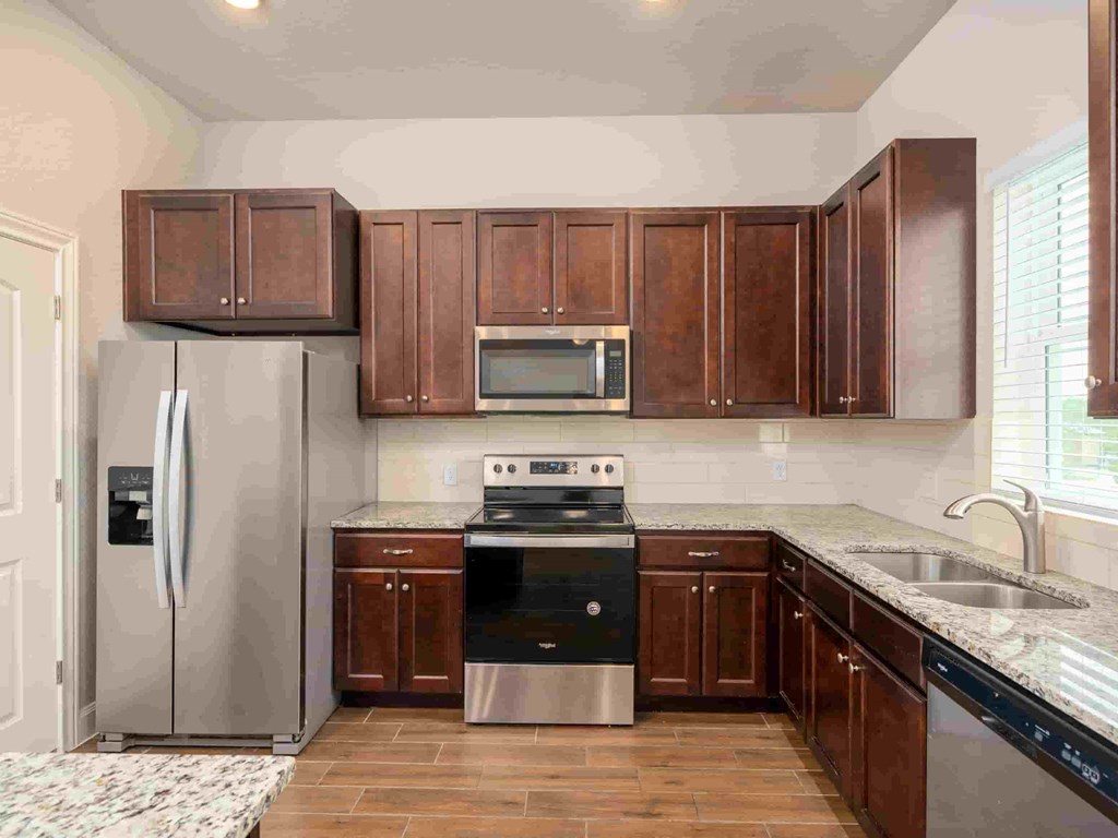 a kitchen with wooden cabinets and stainless steel appliances