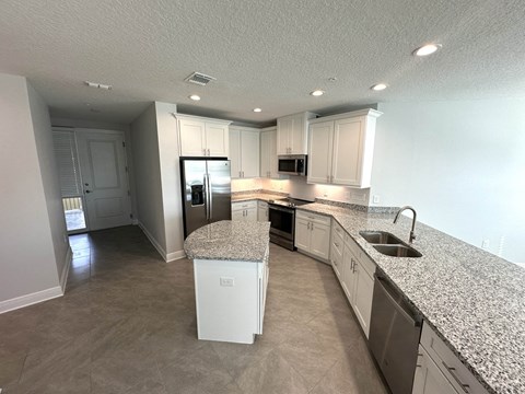 a kitchen with white cabinets and granite counter tops