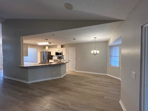 A kitchen area with a bar counter and a refrigerator.