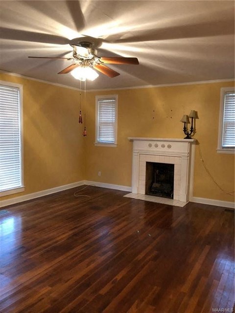 a living room with a fireplace and a ceiling fan