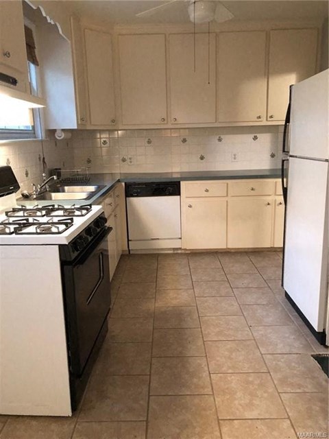 a kitchen with white cabinets and a stove and a refrigerator