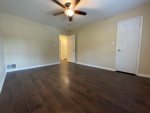 A room with a ceiling fan and two doors.