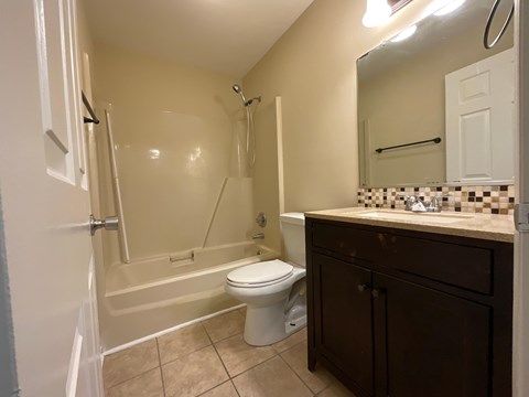 A bathroom with a toilet, sink, and shower.