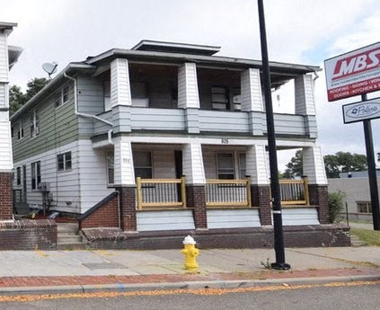 A two-story house with a sign that says LMBS on the right.