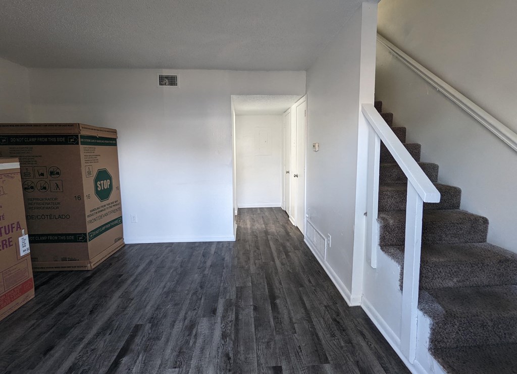 a look down the stairs of a house with boxes on the ground