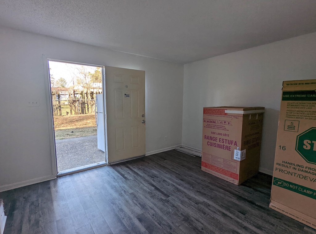an empty room with a door and boxes on the floor