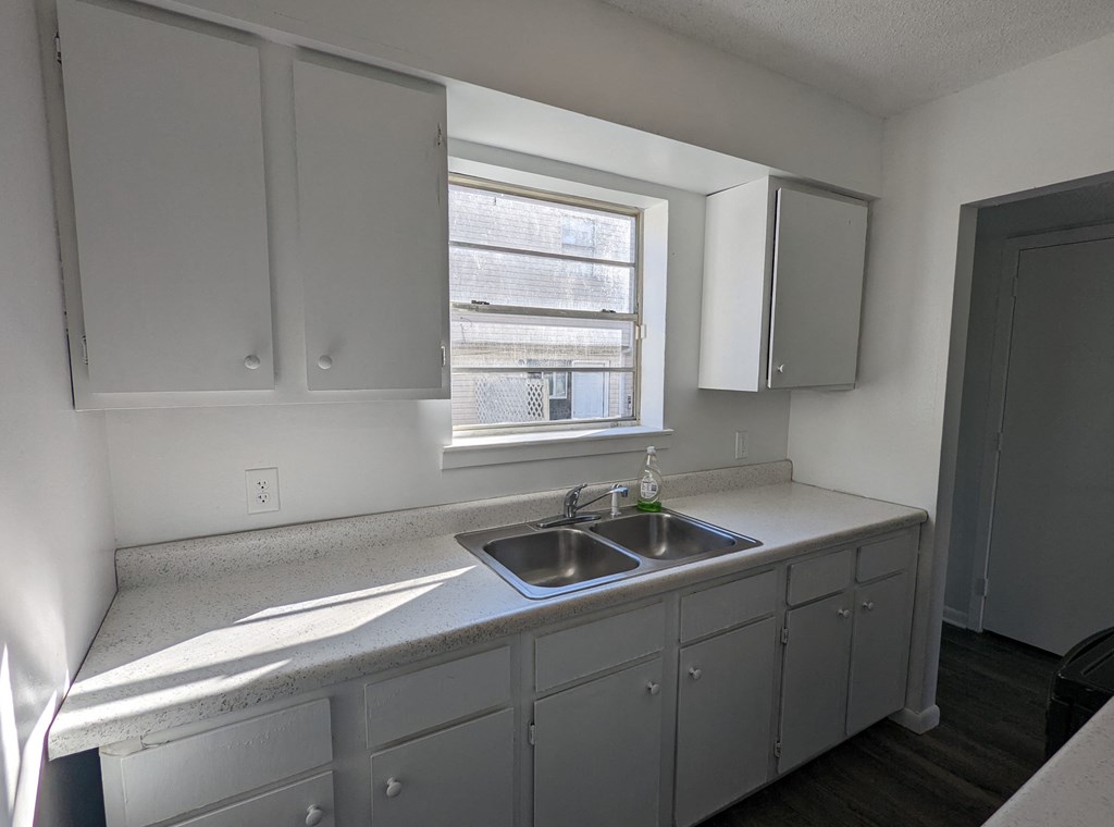 an empty kitchen with a sink and a window