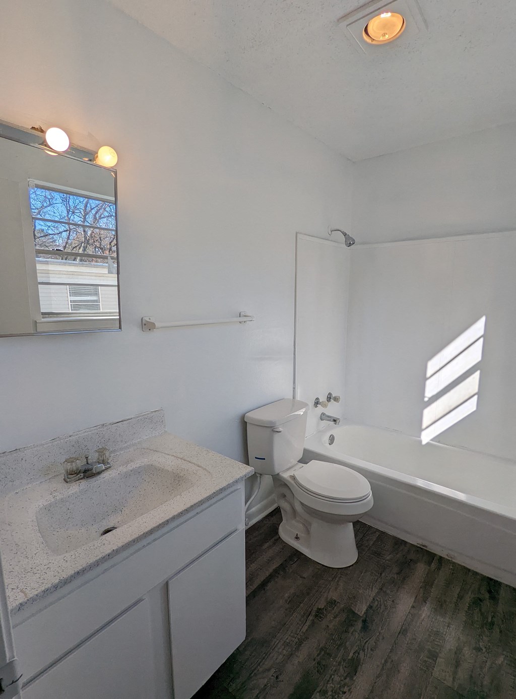 an empty bathroom with a toilet and a tub and a sink