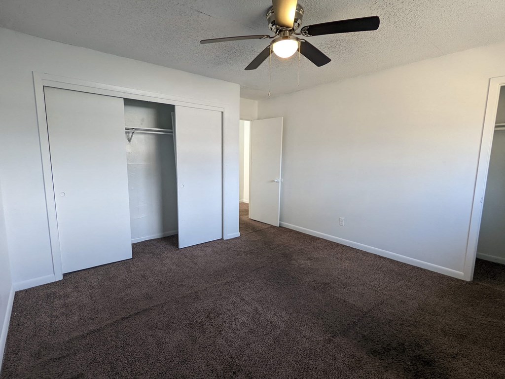 a living room with carpet and a ceiling fan